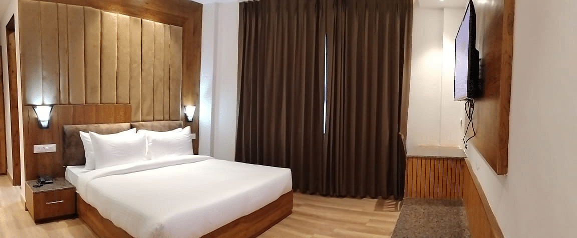 A large bed in front of the TV in Deluxe Non-view Room at DLS Ark Holiday Inn, Banikhet.
