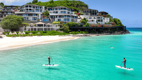 A couple of guests paddle-boarding in waters near the beaches at Tamarind Hills Resort and Villas - Antigua.