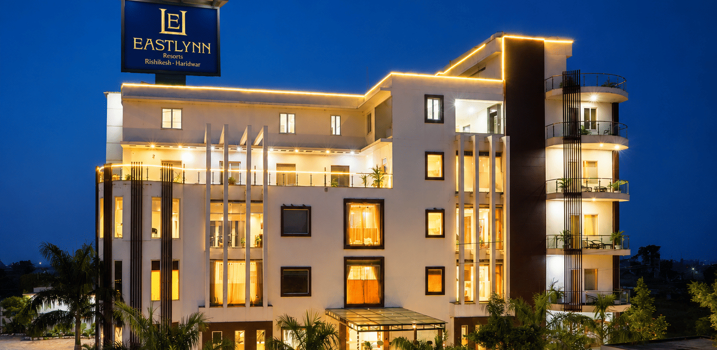 Multi storey hotel exterior lit up against the night sky at Eastlynn Resort, Rishikesh.
