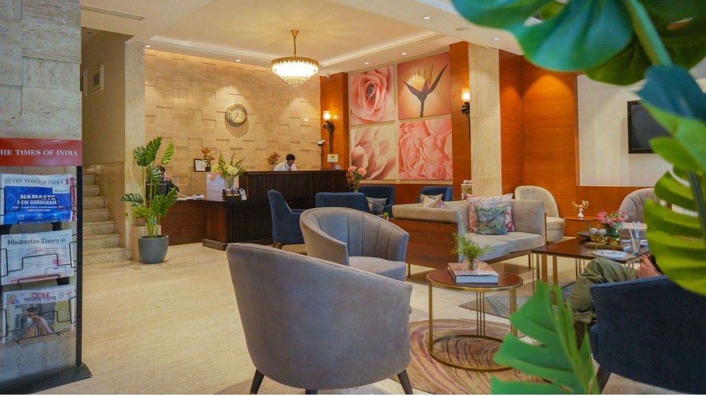 A welcoming lobby at Hotel Saket 27, featuring plush seating, warm lighting, and vibrant decor.