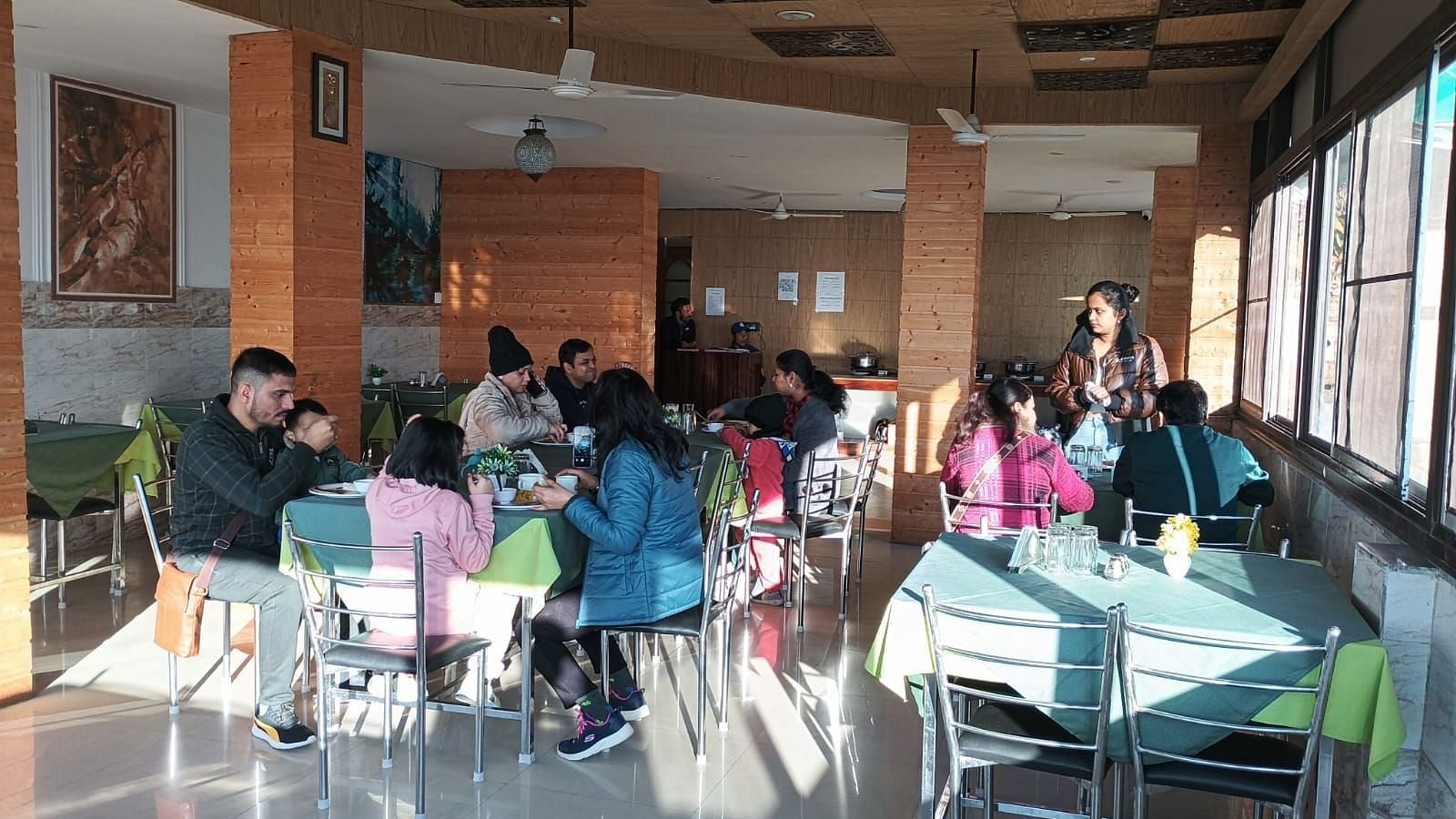 A group of people dining in a bright restaurant with modern décor and large windows.