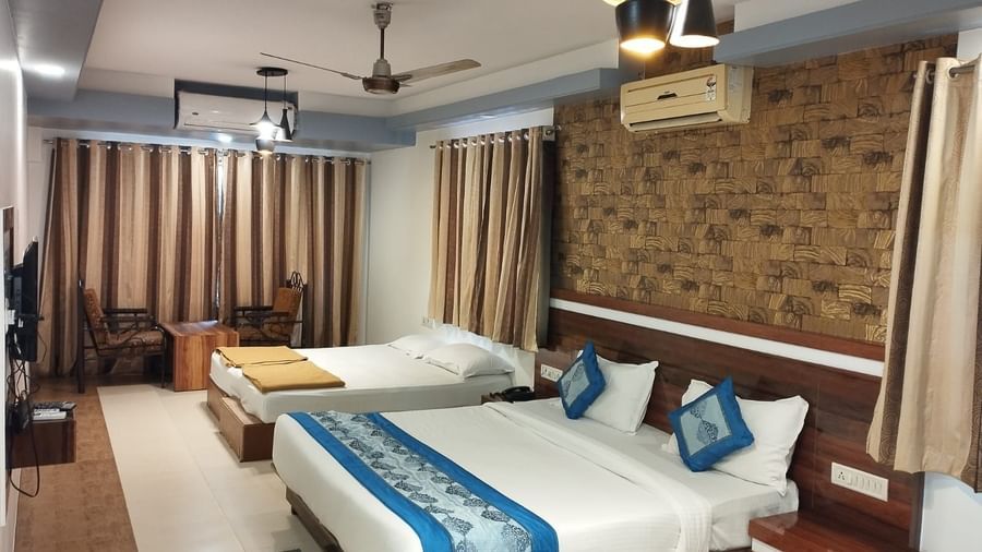 The Suite at Mountview Resort, furnished with two king size beds, drawn curtains, air-conditioning, and a seating area.