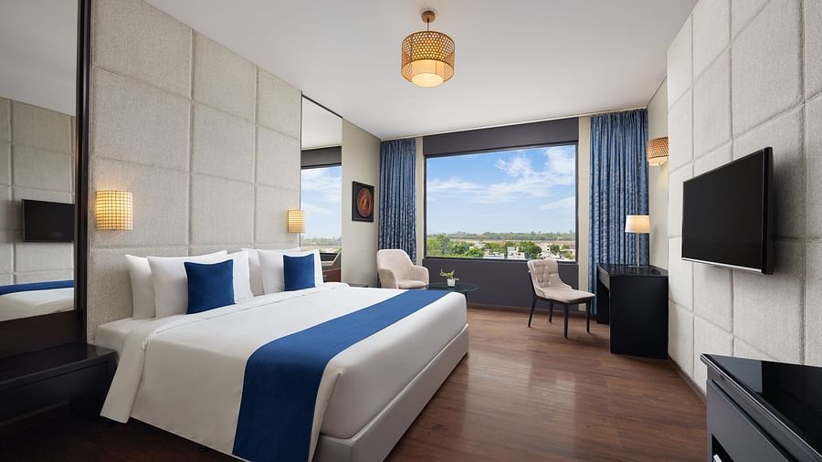 Deluxe king room at Essentia Luxury Hotel, Indore with a double bed and a television