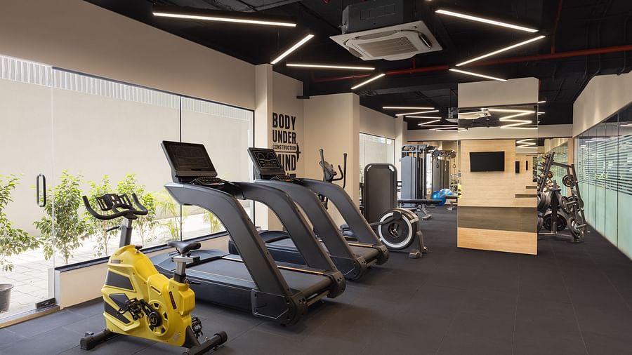 Gym at Essentia Luxury Hotel, Indore with cardio equipment placed near the windows