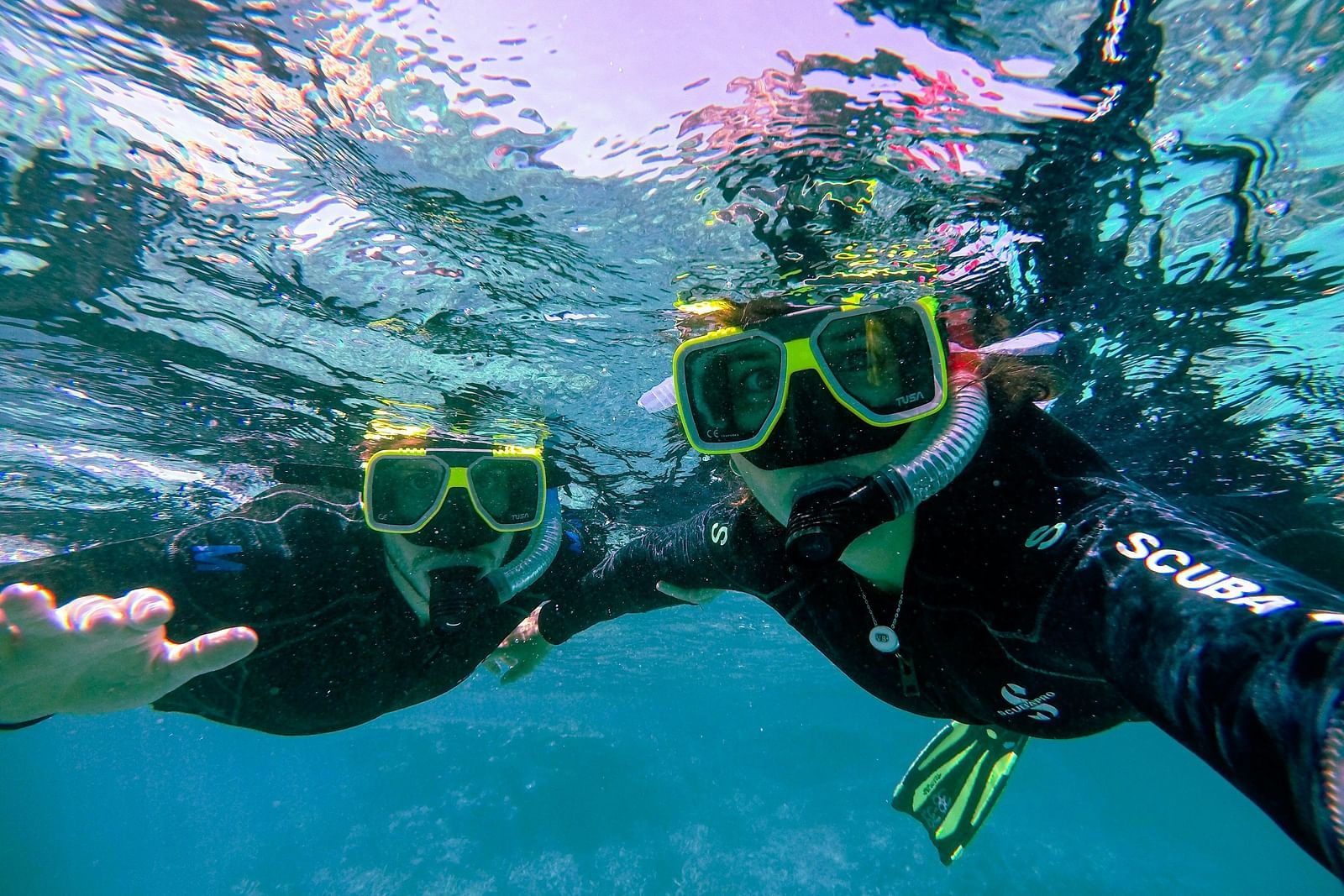 Divers with safety gear, exploring vibrant under waters