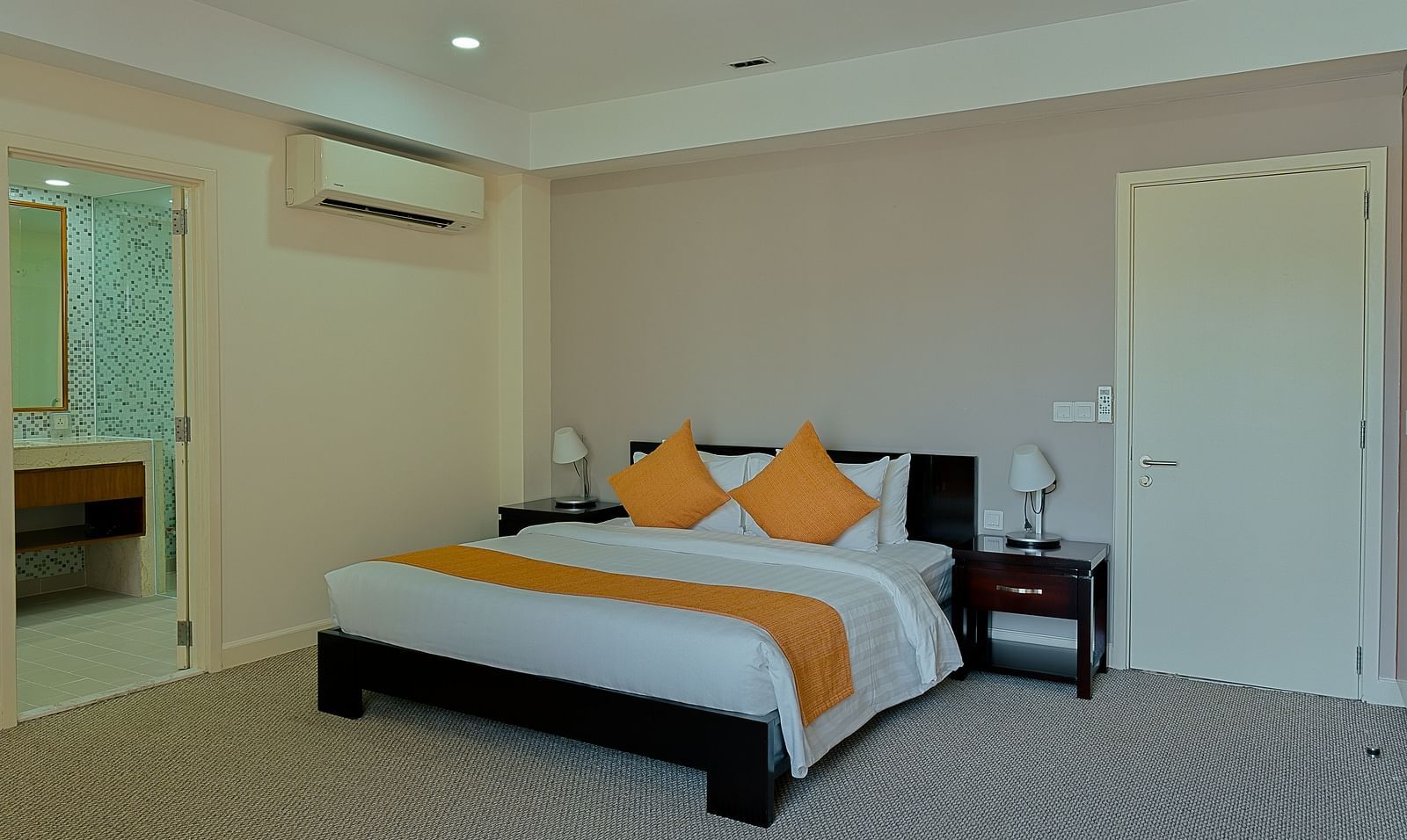 A bedroom with a bed, bedside tables, and AC | Penthouse | Central Mansions, Phnom Penh