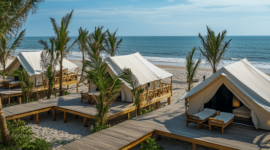 A view of tents on wooden decks by the beach on a clear, blue day