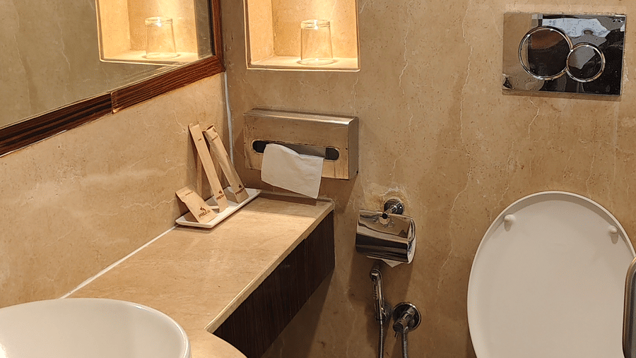 Bathroom of Superior room twin at Pride Premier Chennai featuring a sink with faucet, mirror on the wall, a commode, and other toiletries.
