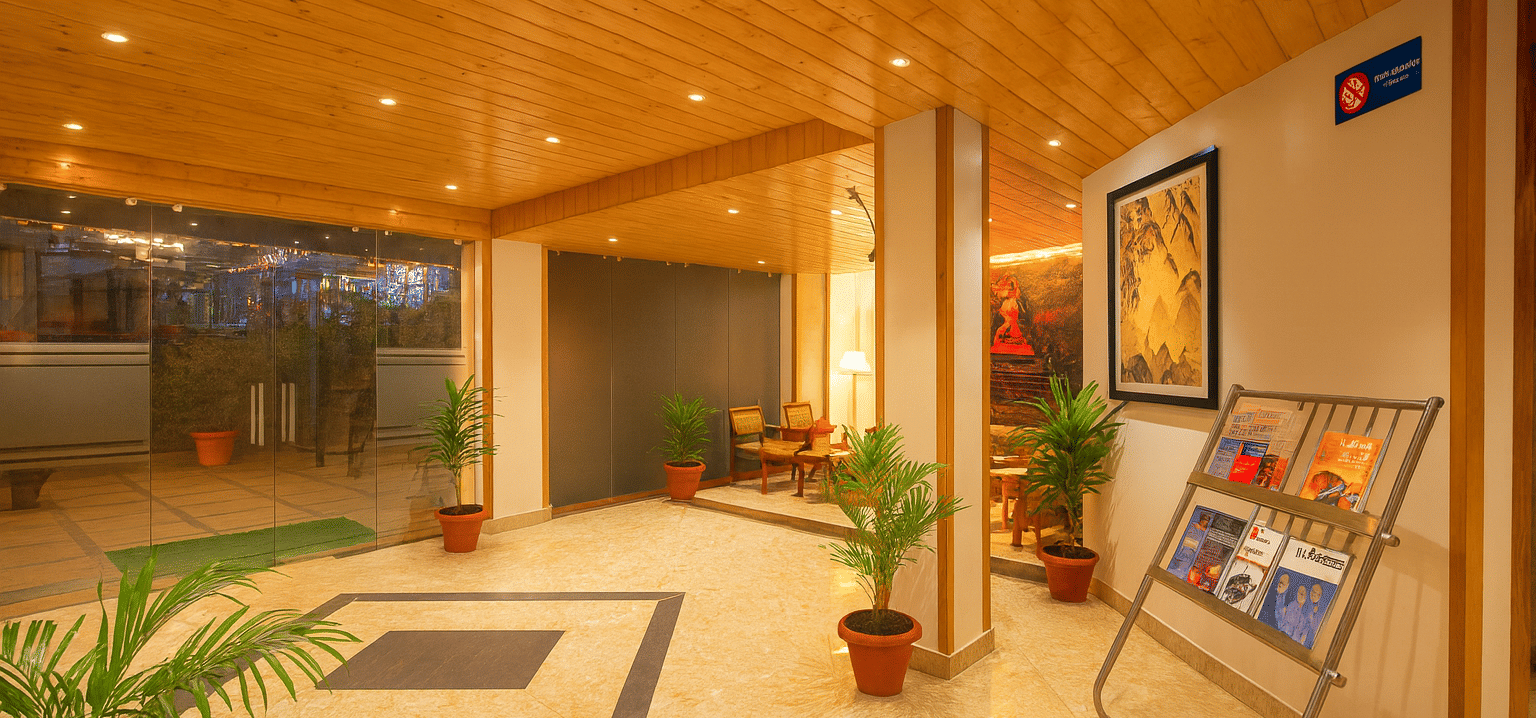 Spacious 3-star hotel lobby in Gangtok with wooden ceiling, marble flooring, indoor plants, and premium warm lighting creating a welcoming ambience