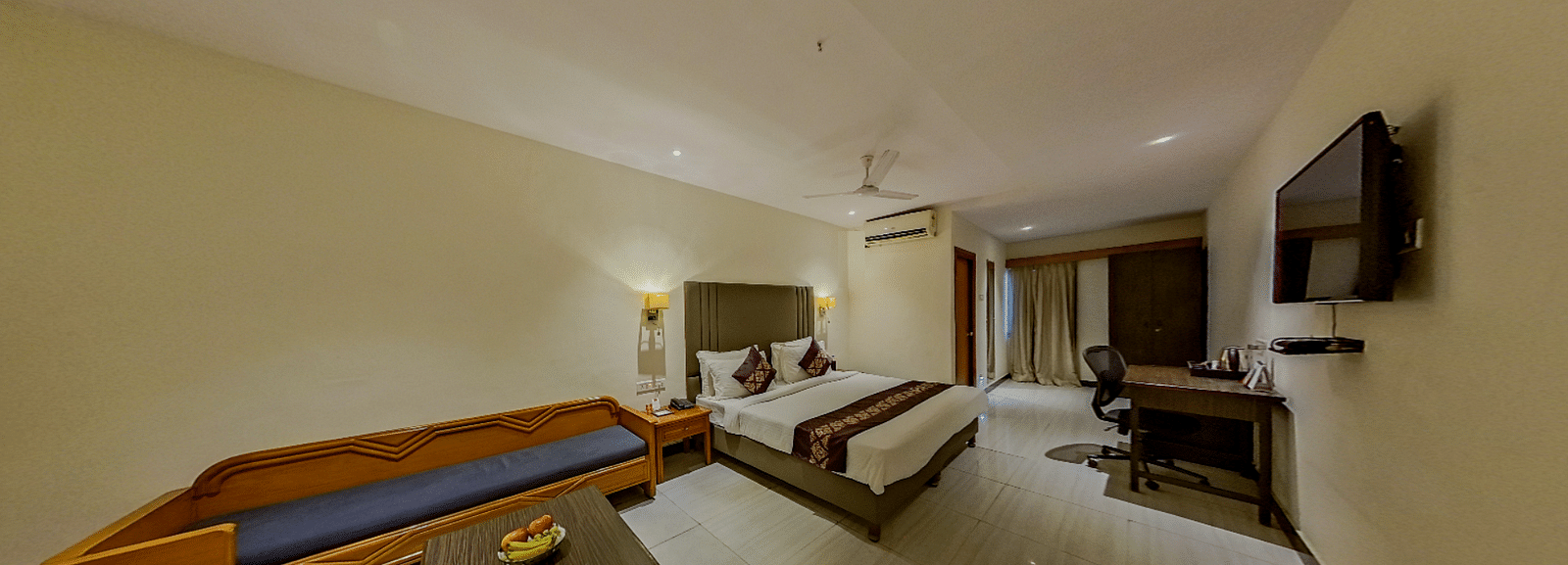 Deluxe hotel suite at Lords Eco Inn Dahej with comfortable seating area, work desk, modern interiors, and panoramic room layout