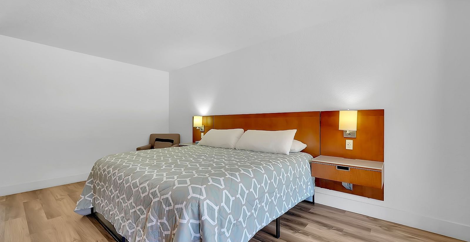A view of a room at Amador Hotel with a double bed and side lamps.