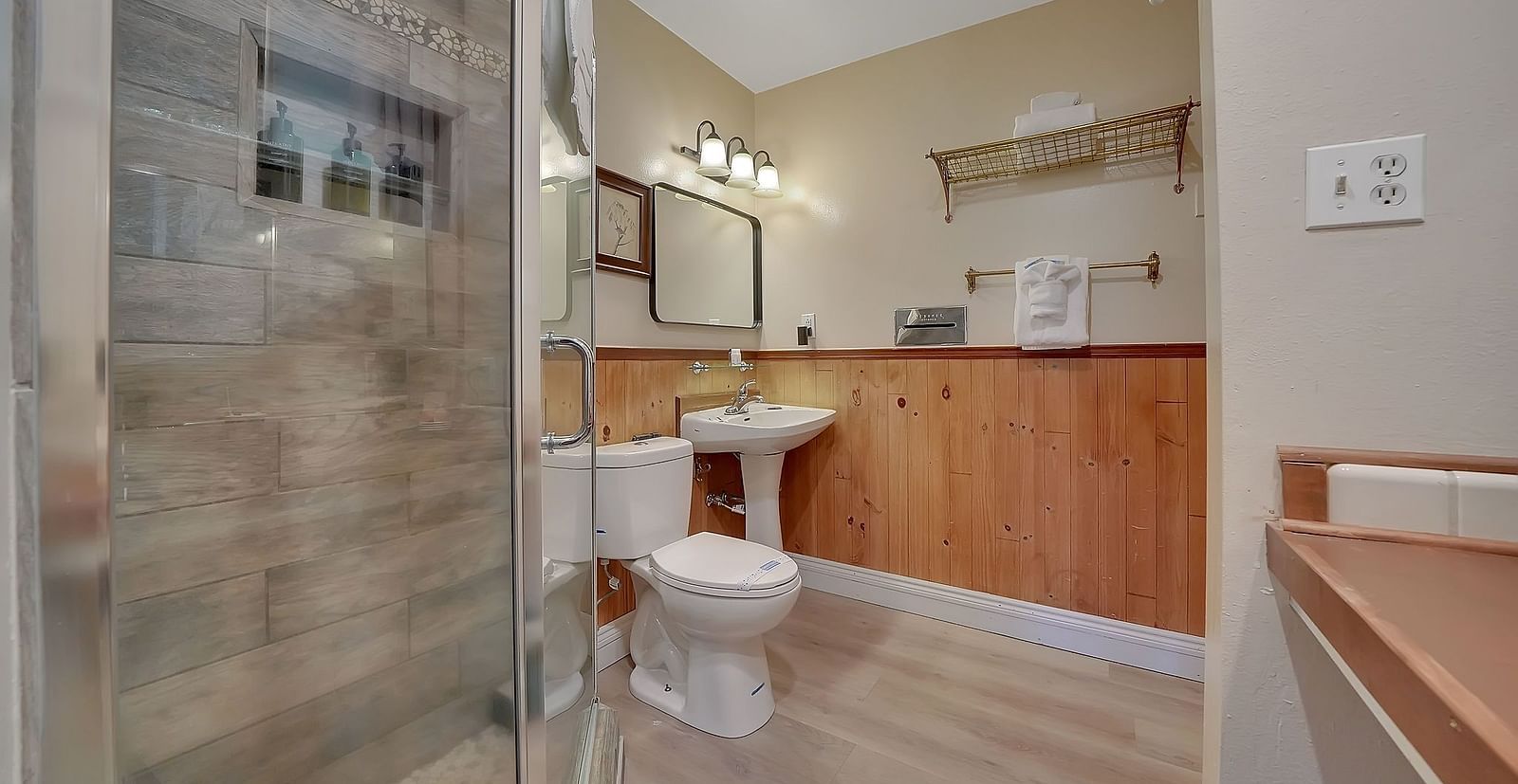 Interiors of a washroom at Narrow Gauge Inn with a separate shower cubicle and a large, well-lit vanity area