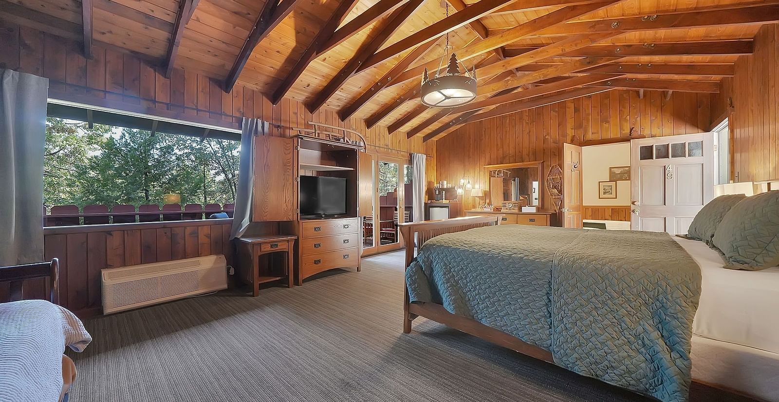 A view of a room at Narrow Gauge Inn with a double bed and wooden interiors.