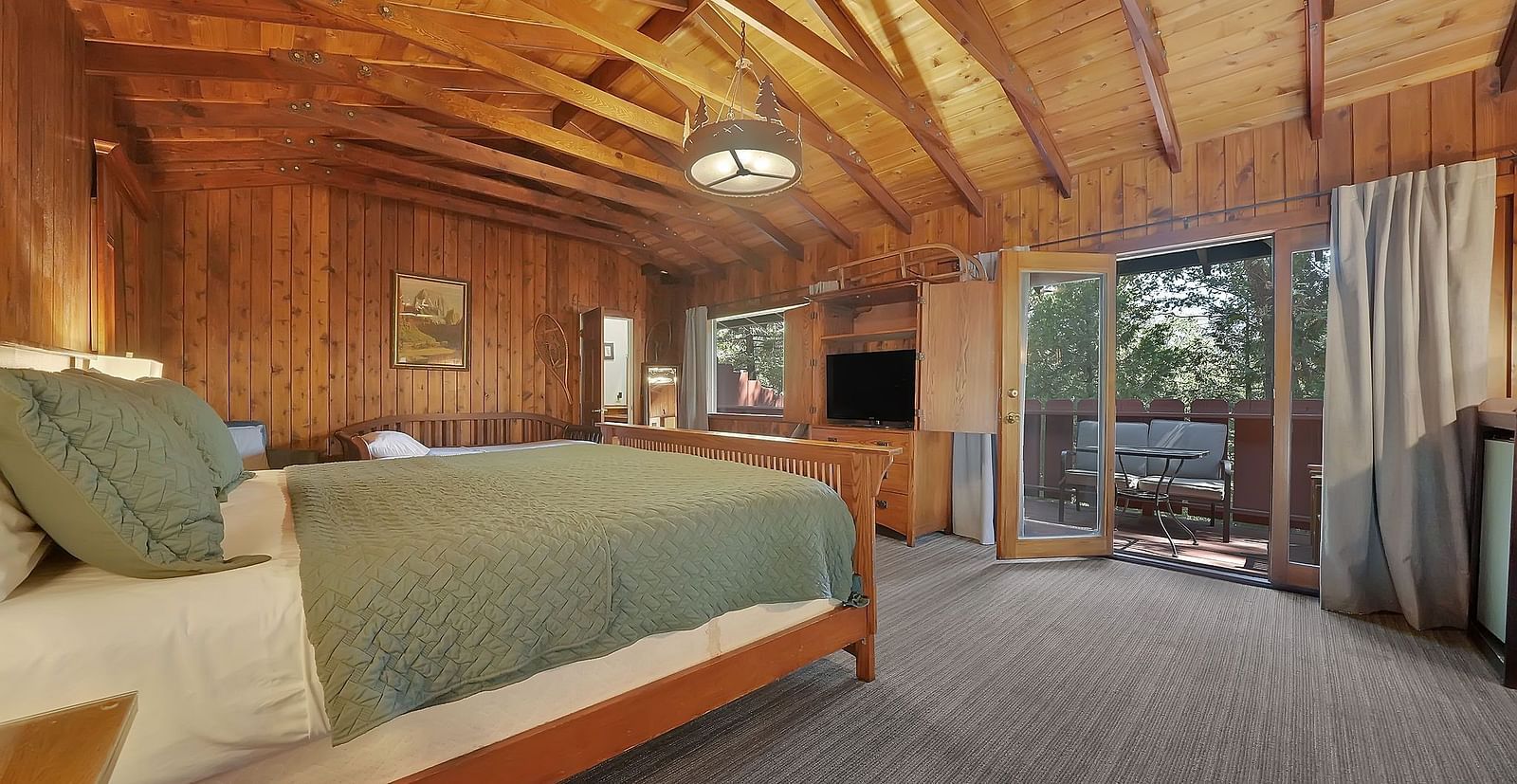 A view of a room at Narrow Gauge Inn with a double bed and wooden interiors.