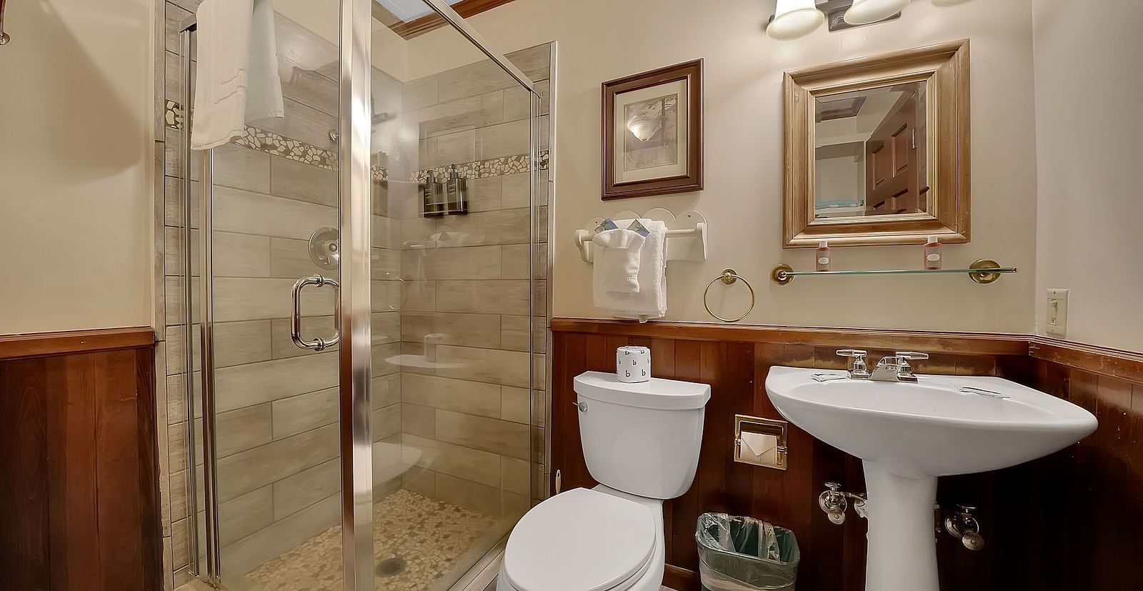 A view of a washroom at Narrow Gauge Inn with a shower cubicle and a vanity area.