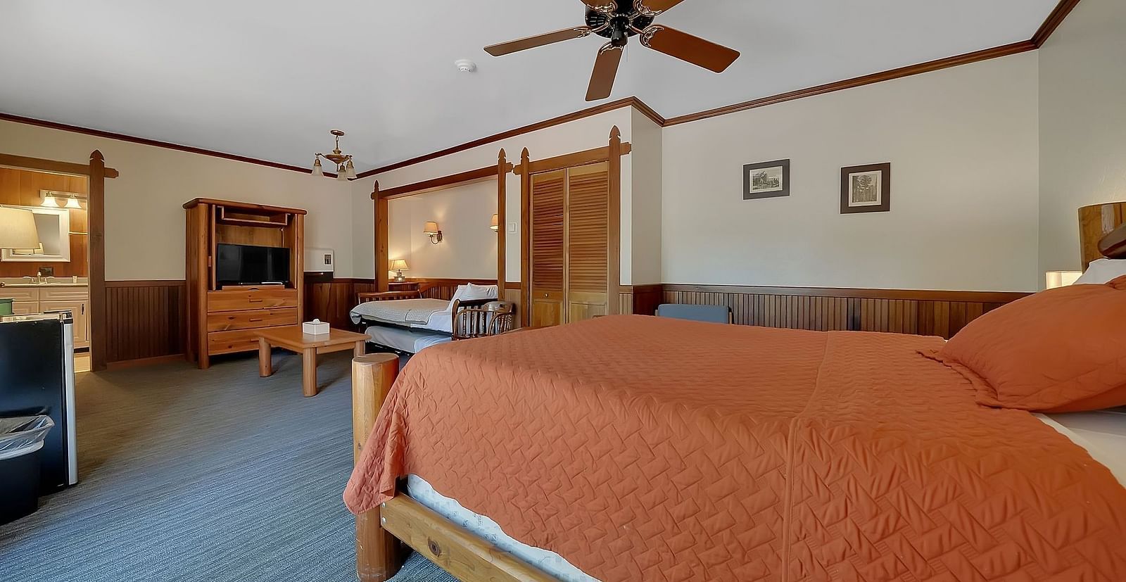 A view of a room at Narrow Gauge Inn with a double bed and a cabinet with a television.