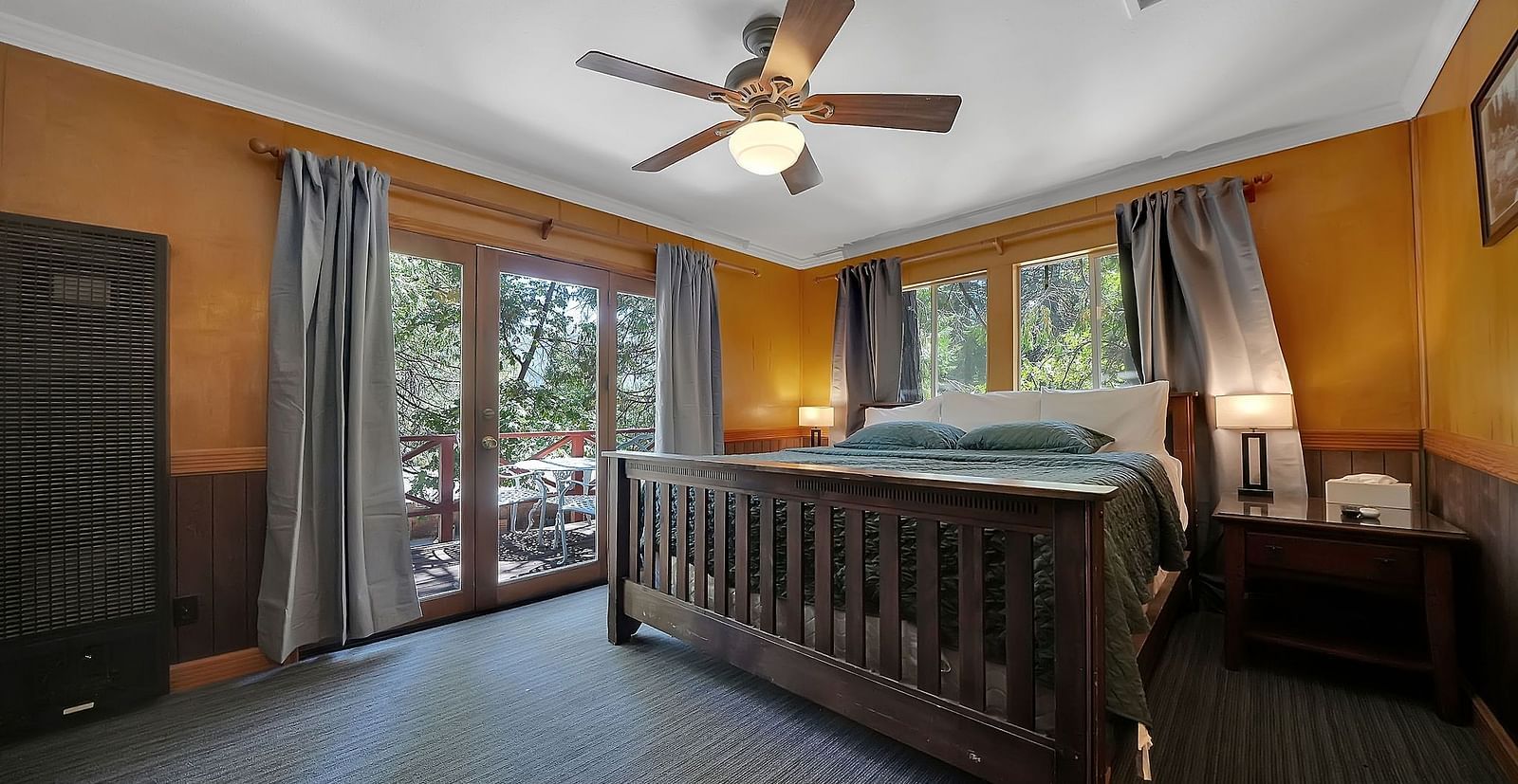 A view of a room at Narrow Gauge Inn with a double bed and sliding doors opening to a balcony.