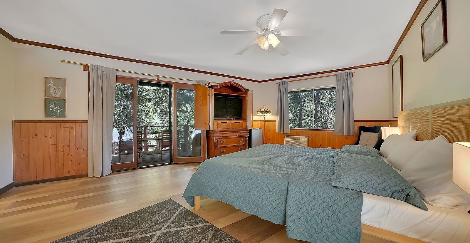 A room at Narrow Gauge Inn with a double bed and sliding doors opening up to a balcony with seating.
