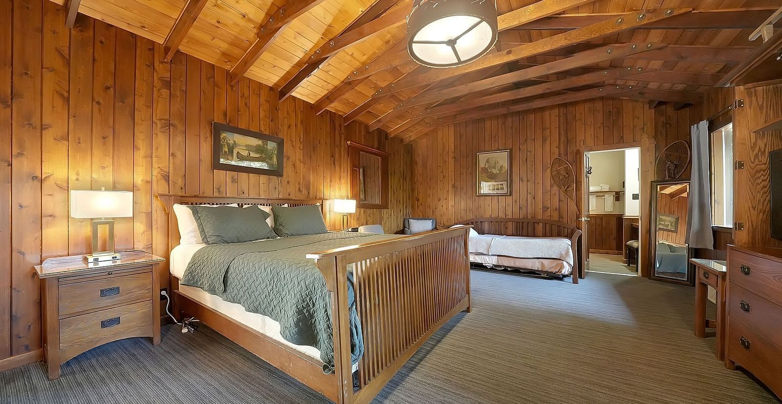 A view of a room at Narrow Gauge Inn with a double bed and wooden interiors.