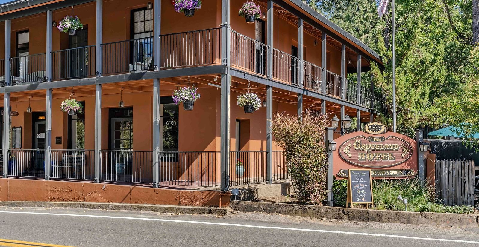 Exterior of a cabin at The Groveland Hotel during the day with the hotel's signage in view.