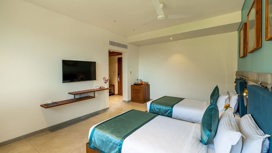 view of a two twin beds and a TV of a Deluxe Room at Stone Wood Hotel, Kumbhalgarh
