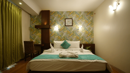 Comfortable double bedroom with patterned accent wall and soft lighting at Pipul Utkal Continental, Jharsuguda.