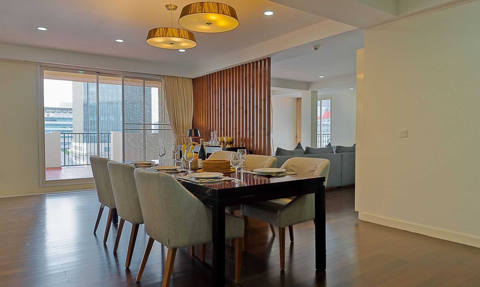 A dining room with a long table, multiple chairs, and a chandelier | Penthouse | Central Mansions, Phnom Penh