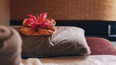 Bed with pillows and flower arrangement in a room at Karma Chalets.