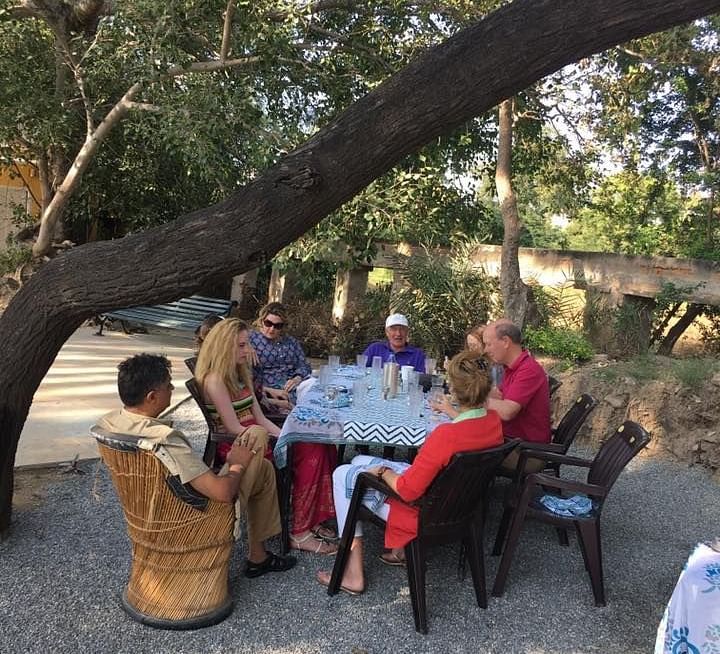 People enjoying a meal in the field - Dev Shree, Deogarh