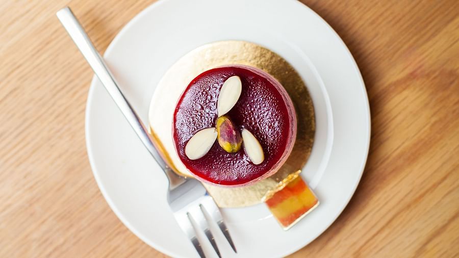 A small dessert is placed on a white plate on a wooden table | The Shop | Central Mansions, Phnom Penh