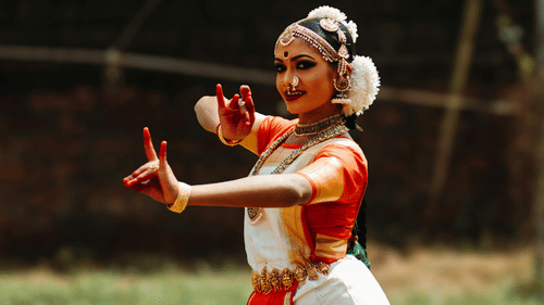An image of a woman in a classical dance outfit holding a pose.