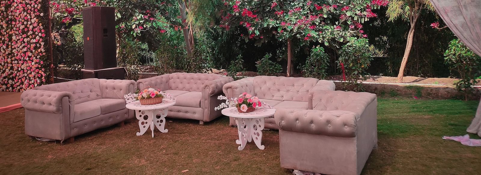 Outdoor event setup with plush sofas, small tables, and a colourful draped ceiling. - Bamboo Saa, Udaipur 