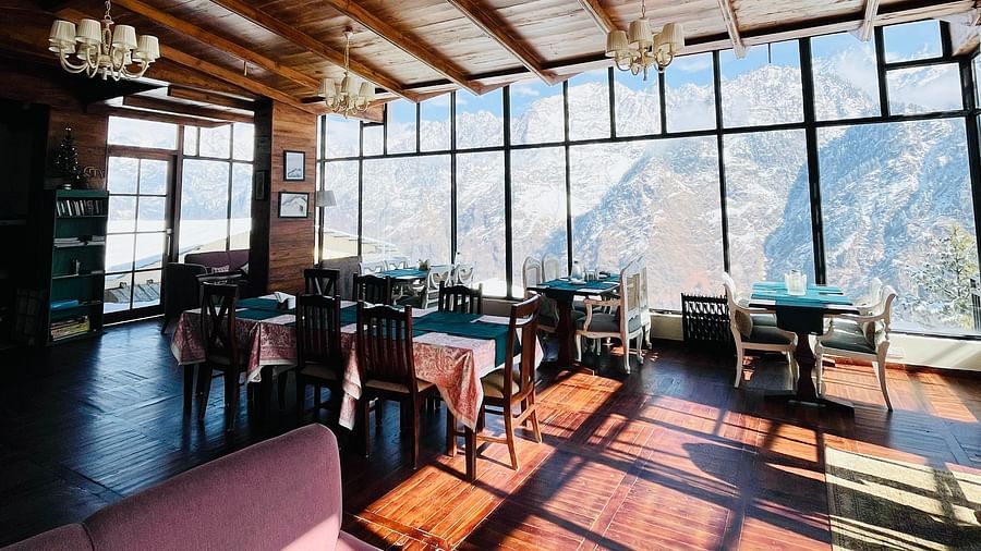 Image of the dining area with wooden ceiling and chandeliers | Faraway Cottages, Auli