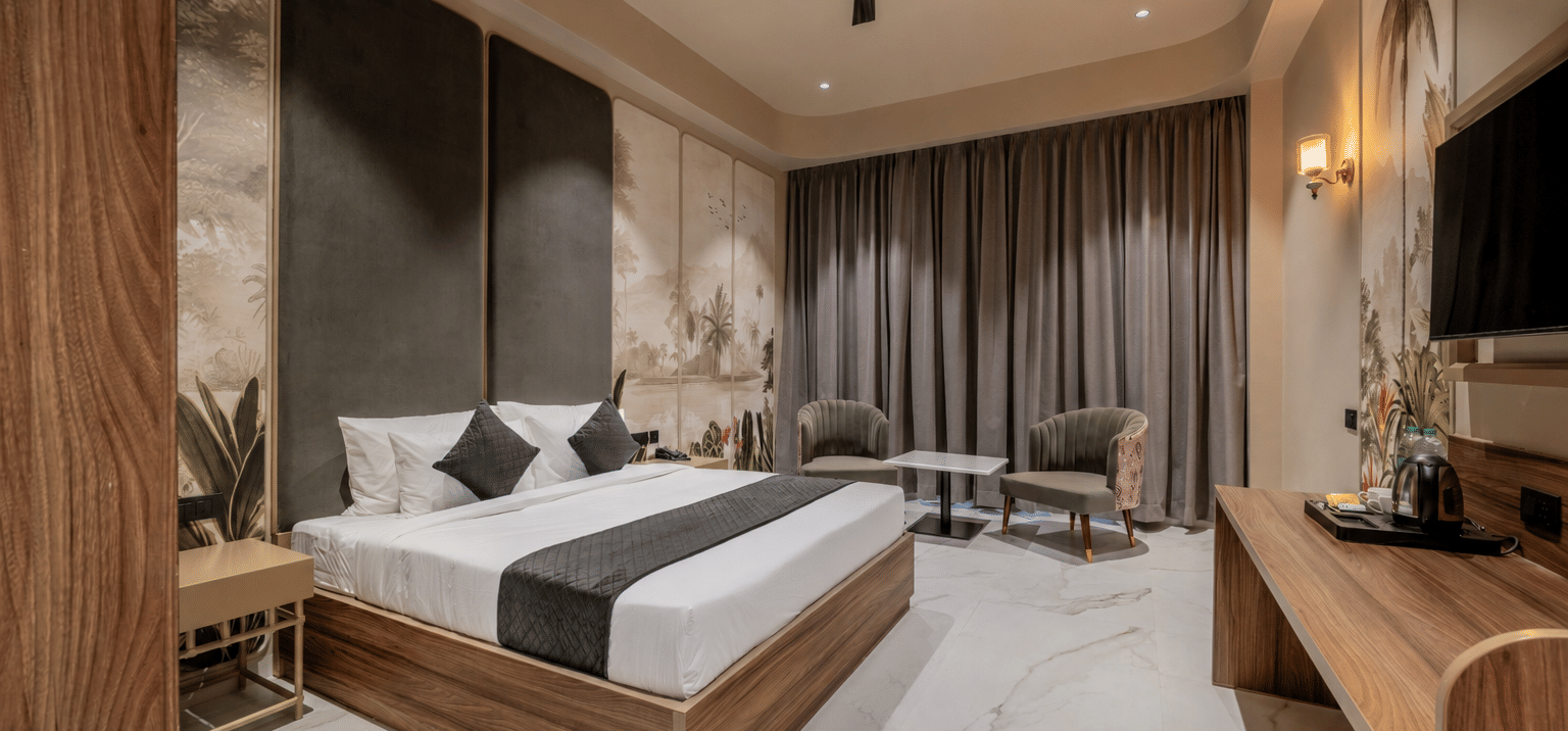 Bedroom with a double bed, wooden wardrobe, television, and upholstered seating.