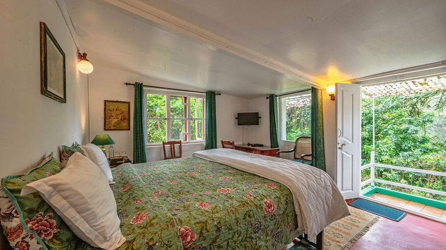 Camphor room at Wallwood Garden - 19th Century, Coonoor with a double bed, floral quilt, garden-facing windows and private sit-out.