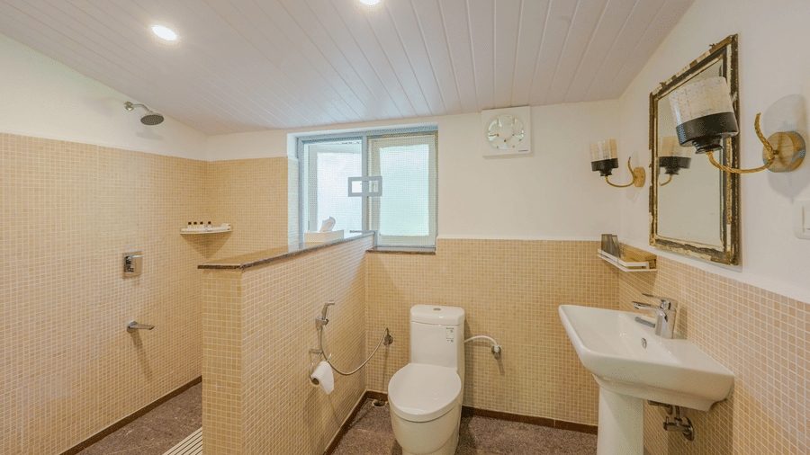 Bathroom of the Cherry Blossom room at Wallwood Garden - 19th Century, Coonoor with walk-in shower, washbasin and modern fittings.