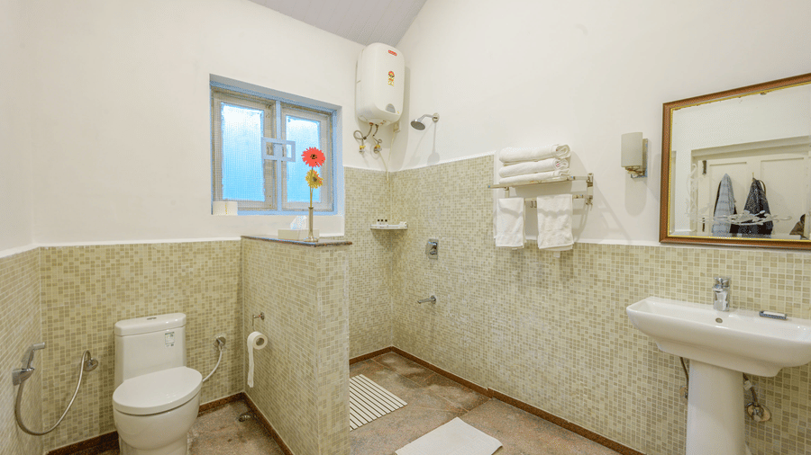 Bathroom of the Silver Oak room at Wallwood Garden - 19th Century, Coonoor with walk-in shower, washbasin and modern fittings.
