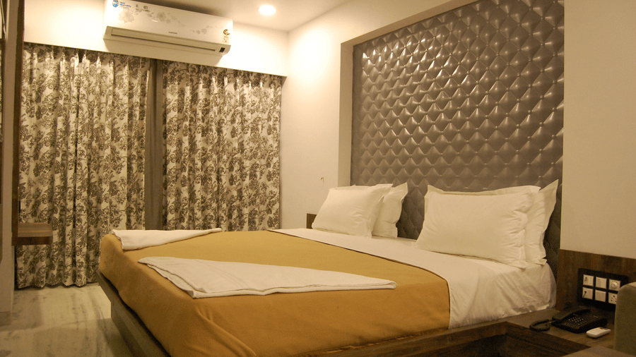Deluxe room at Sanmukh by Adamo with its modern furnishing and subtle lighting.