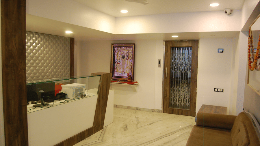 Hotel reception at sanmukh by adamo with its wooden interiors and clean ambience.