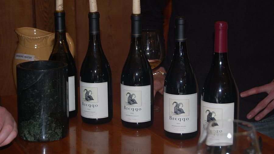 A collection of wine bottles placed on a wooden table - Brewery Gulch Inn & Spa