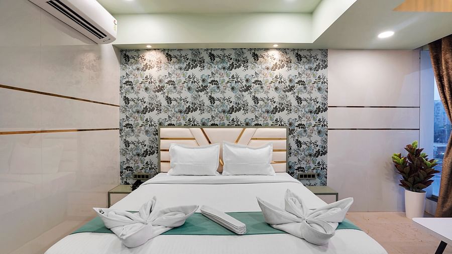 A king size bed of Deluxe Room at Hotel Regal Heaven, Pune.