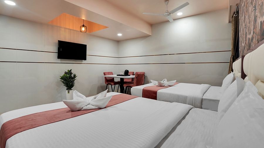 Two king size beds placed in front of television in Family Room at Hotel Regal Heaven, Pune.