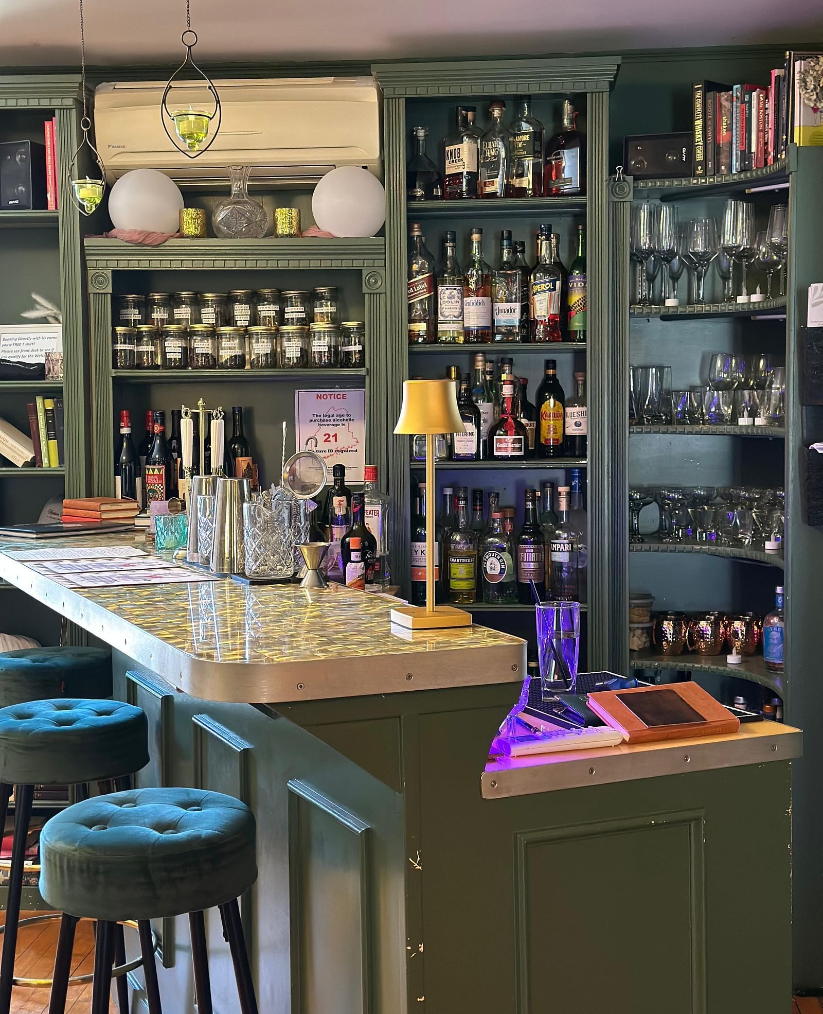 Upscale bar at Hartstone Inn stocked with a variety of liquor bottles, glassware, and cozy seating.