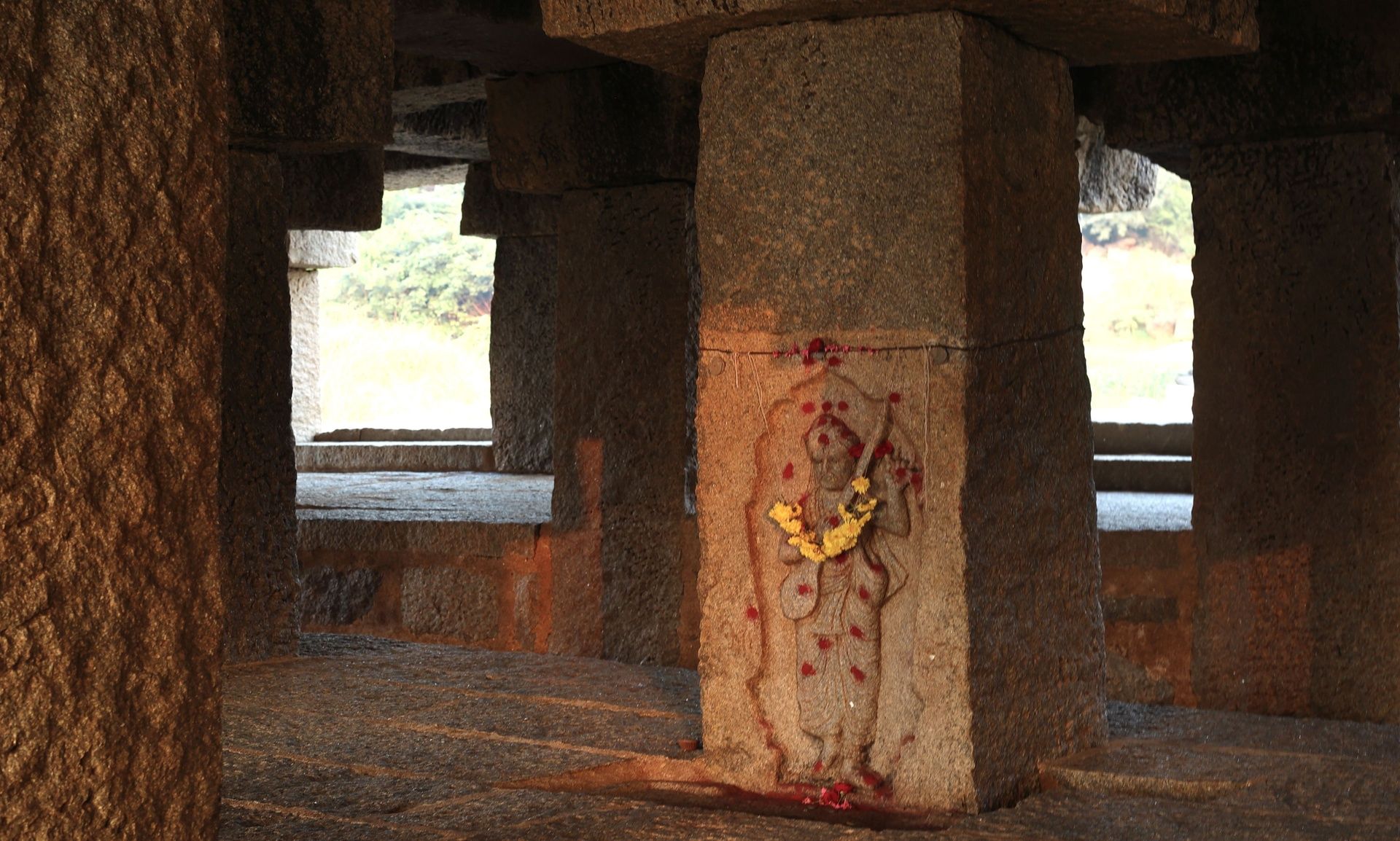 Stone pillar with Purandara Dasa sculpture in Hampi.