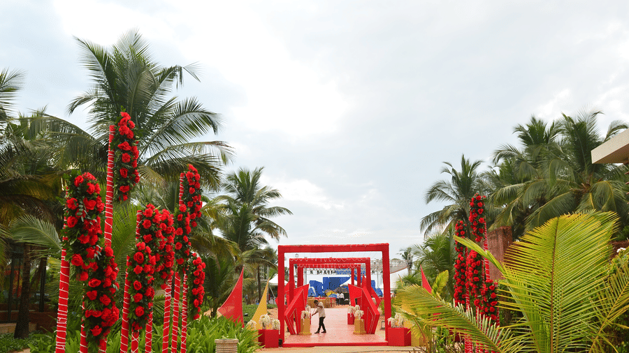 Red flower arrangements by a sandy pathway at one of the best wedding venues in south goa