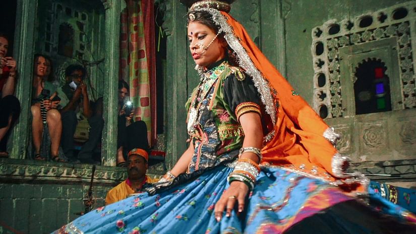 a cultural performance by a woman inside bagore ki haveli.