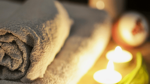 Towels and candles in a dimly lit spa setting