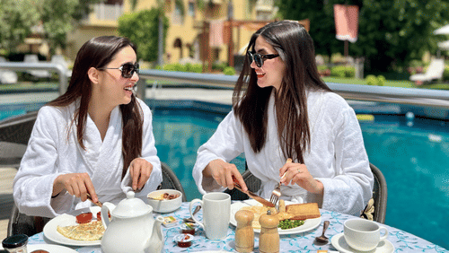 2 women enjoying a poolside breakfast spread - Heritage Village Resort & Spa, Manesar