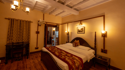 Side view of Heritage Room with a cosy bed and stylish interior lighting at Himalaya Hotel, Nainital