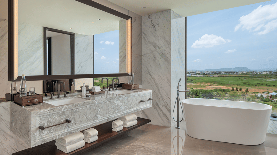 Executive Suite Room 8027 master bathroom with a freestanding tub and marble washbasin at The Residency Signature Madurai.